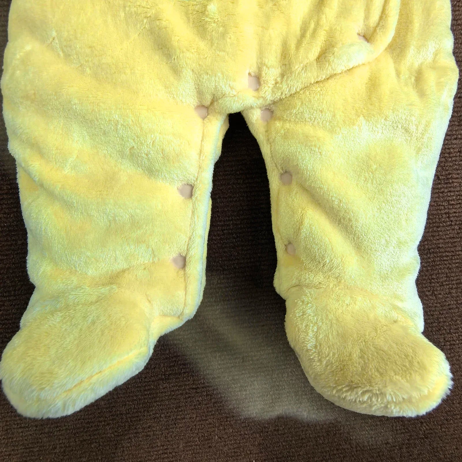 Macacão infantil com capuz e pezinhos, fechamento por botões de pressão, forro de lã, faixa para a cabeça e proteção para os pés. Macacão de inverno com estampa fofa.